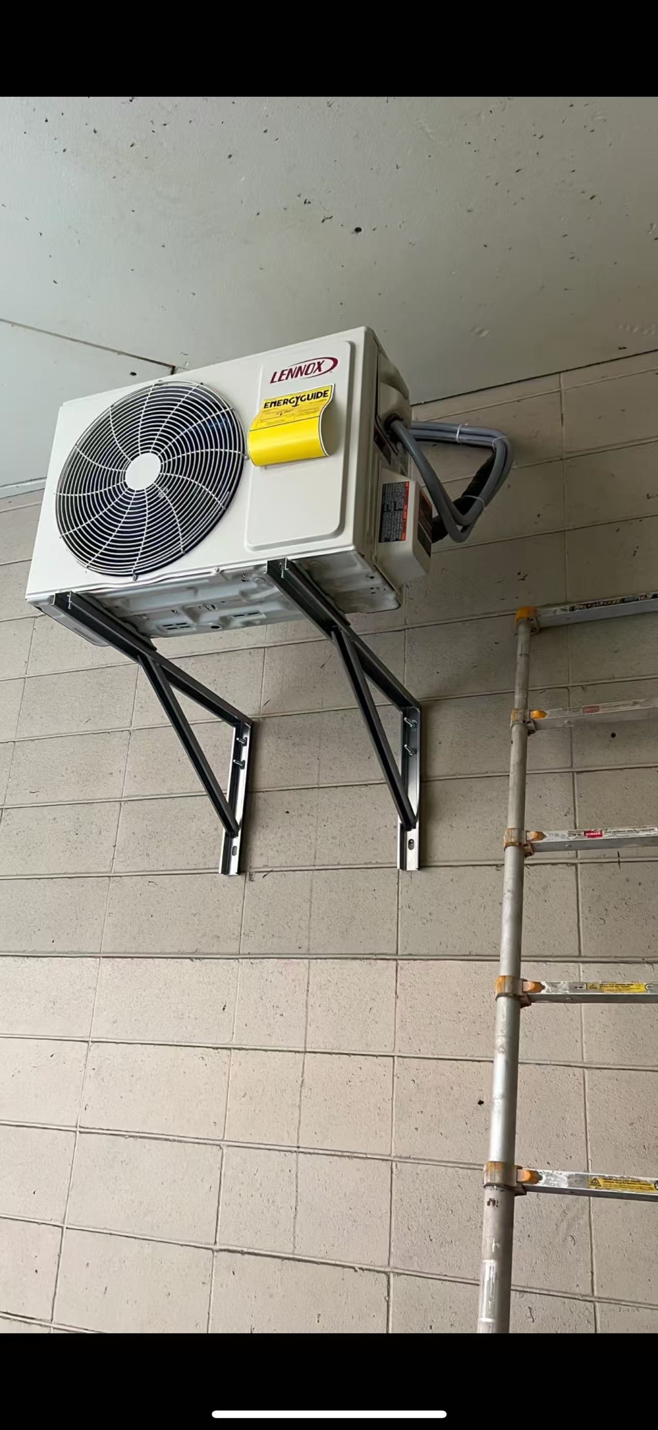 Mini-split outdoor unit mounted high on wall brackets